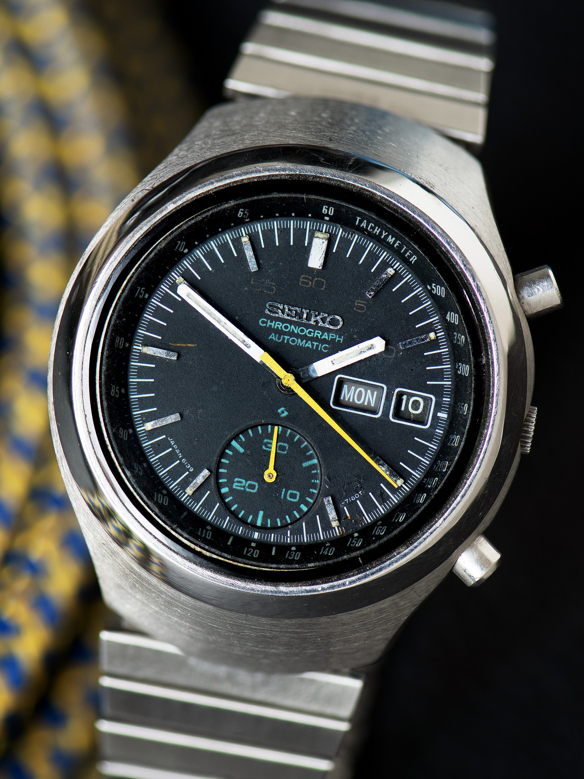 Seiko 6139-7100, Black Dial, Yellow Chronograph Hands. Documented specimen has restored hand lume. Photo: Craft + Tailored. · Photo: Craft + Tailored · © Craft + Tailored, used with permission · Source: https://www.craftandtailored.com/products/1977-seiko-automatic-chronograph-ref-6139-7100